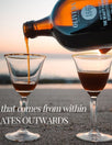 Botella vertiendo elixir en dos copas sobre la playa al atardecer, texto sobreimpreso: BEAUTY, that comes from within and RADIATES OUTWARDS