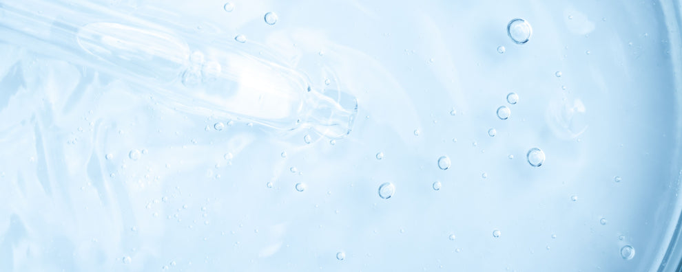 Clear serum with glass dropper and suspended bubbles on pale blue background