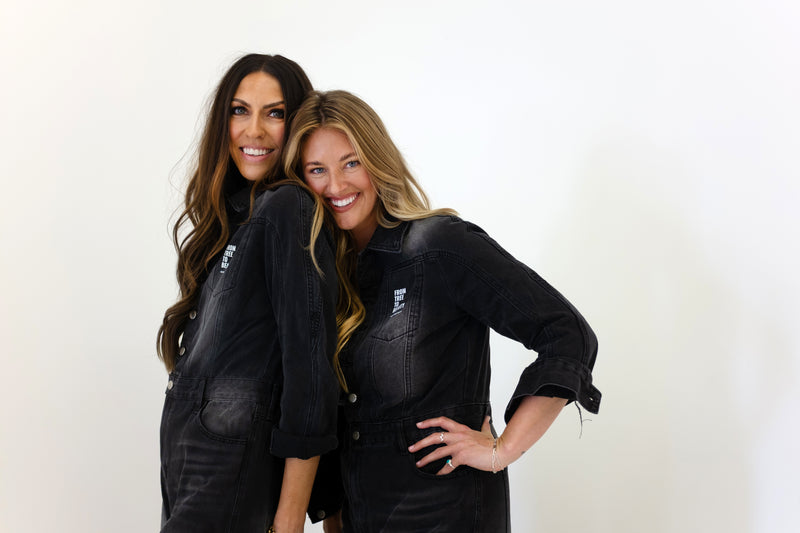 Two smiling female models in Olive Tree People jumpsuits 