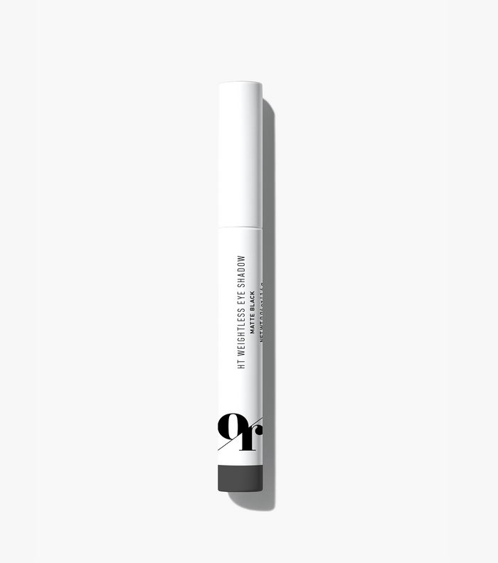 Slim white eye-shadow pen labeled 'HT WEIGHTLESS EYE SHADOW' and 'MATTE BLACK', with black 'gr' logo, casting shadow