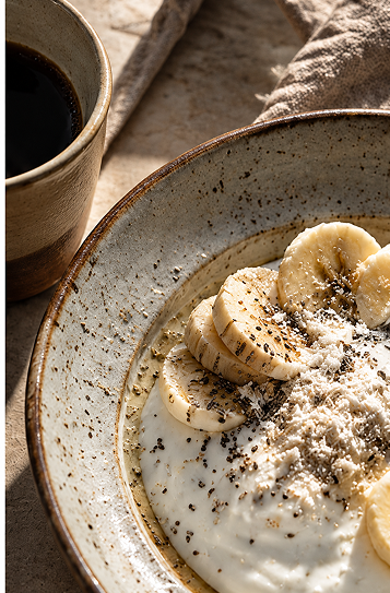 A bowl of yogurt with chia seeds, banana, and Aristaeos product on top.