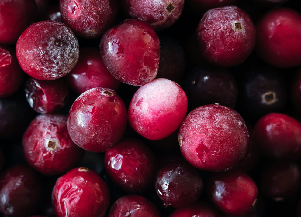 Close-up of frosted cranberries with water droplets, deep red and pink berries