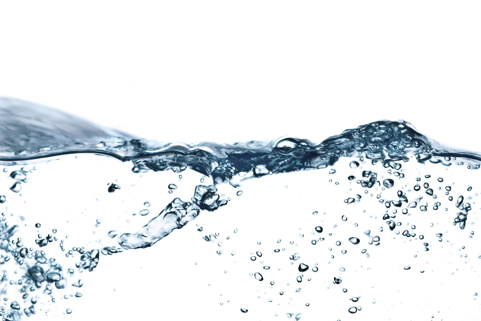 Clear water surface with a wave and suspended bubbles on a white background