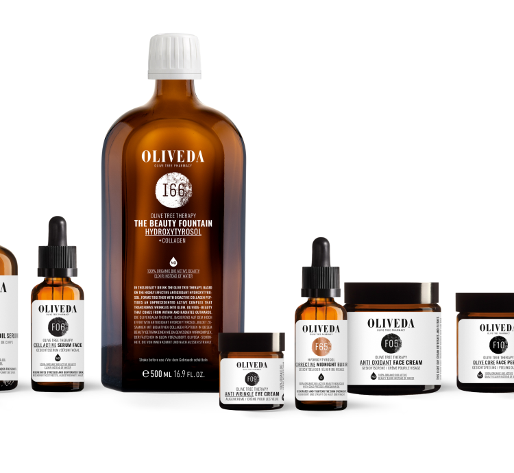 Oliveda amber skincare lineup with central '166' Beauty Fountain bottle and assorted serums and creams.
